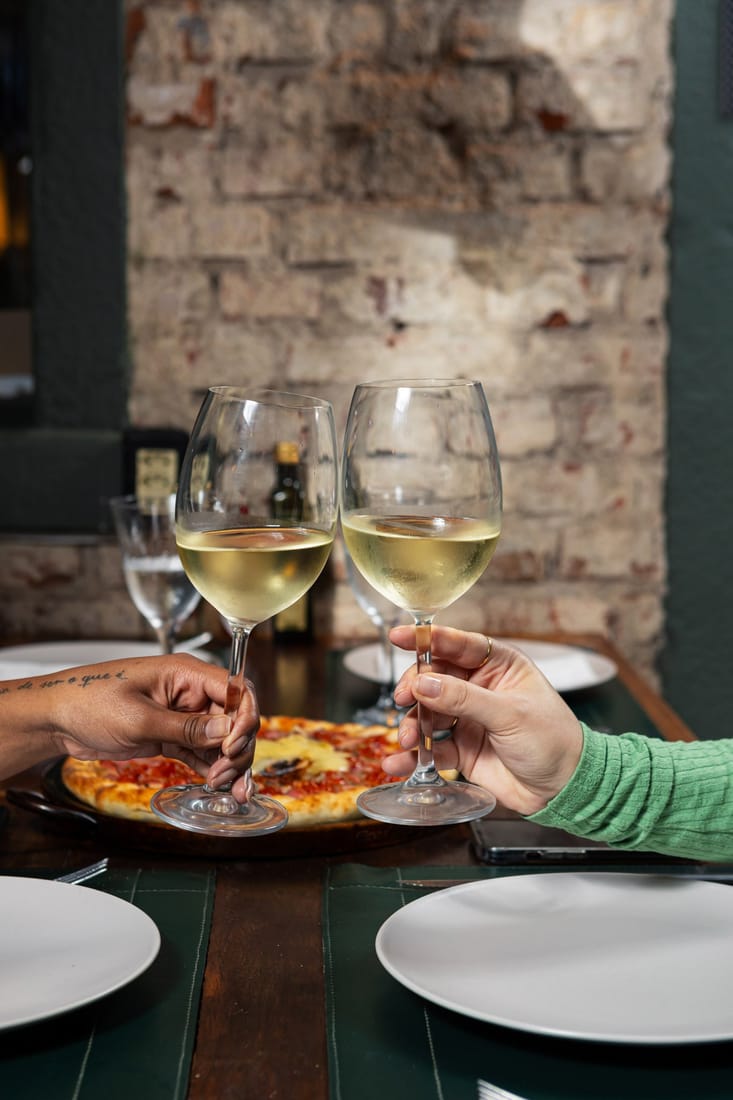 Duas taças de vinho branco num brinde à mesa